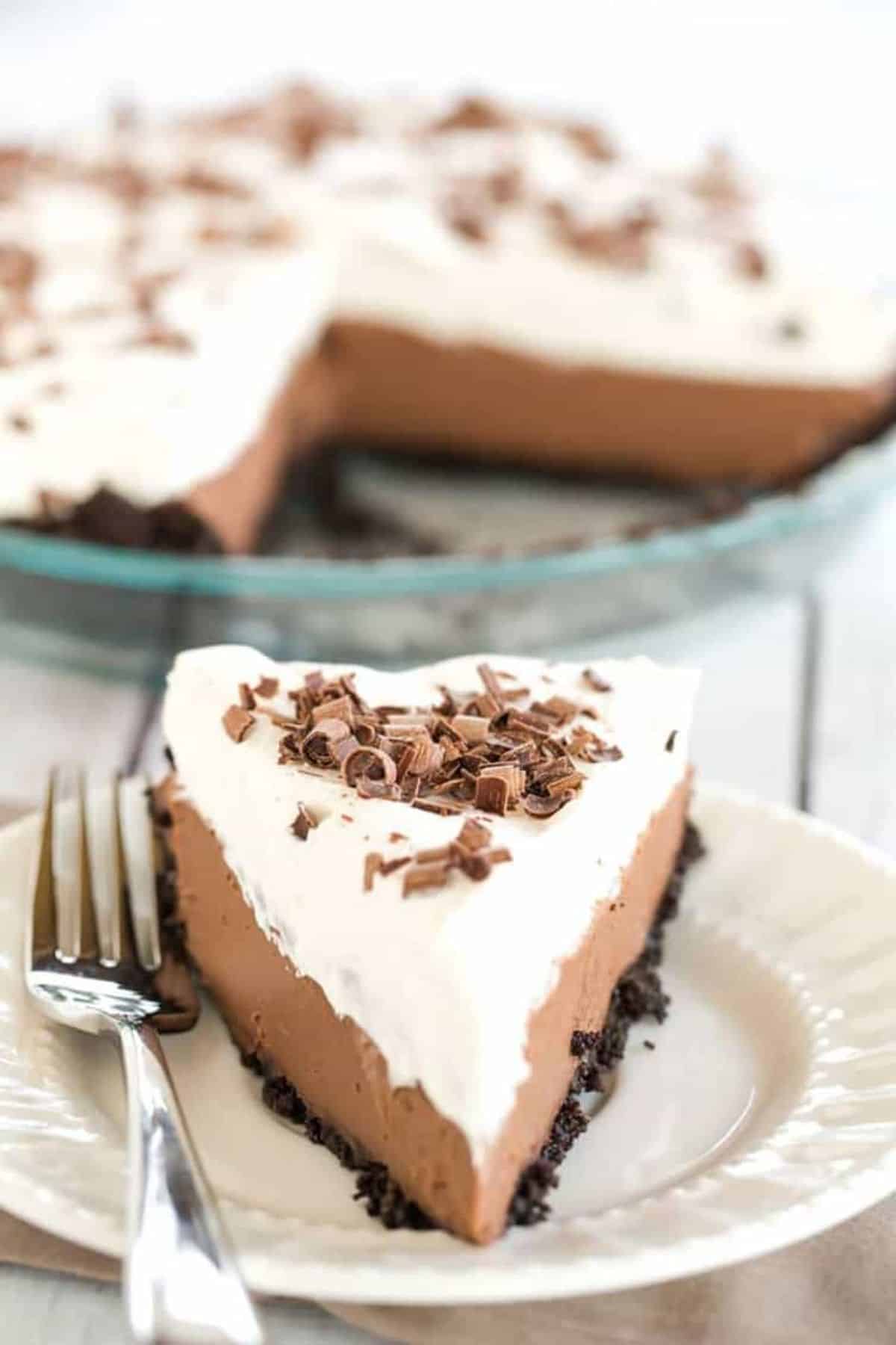 A piece of Chocolate Cream Pie on a white plate with a fork.