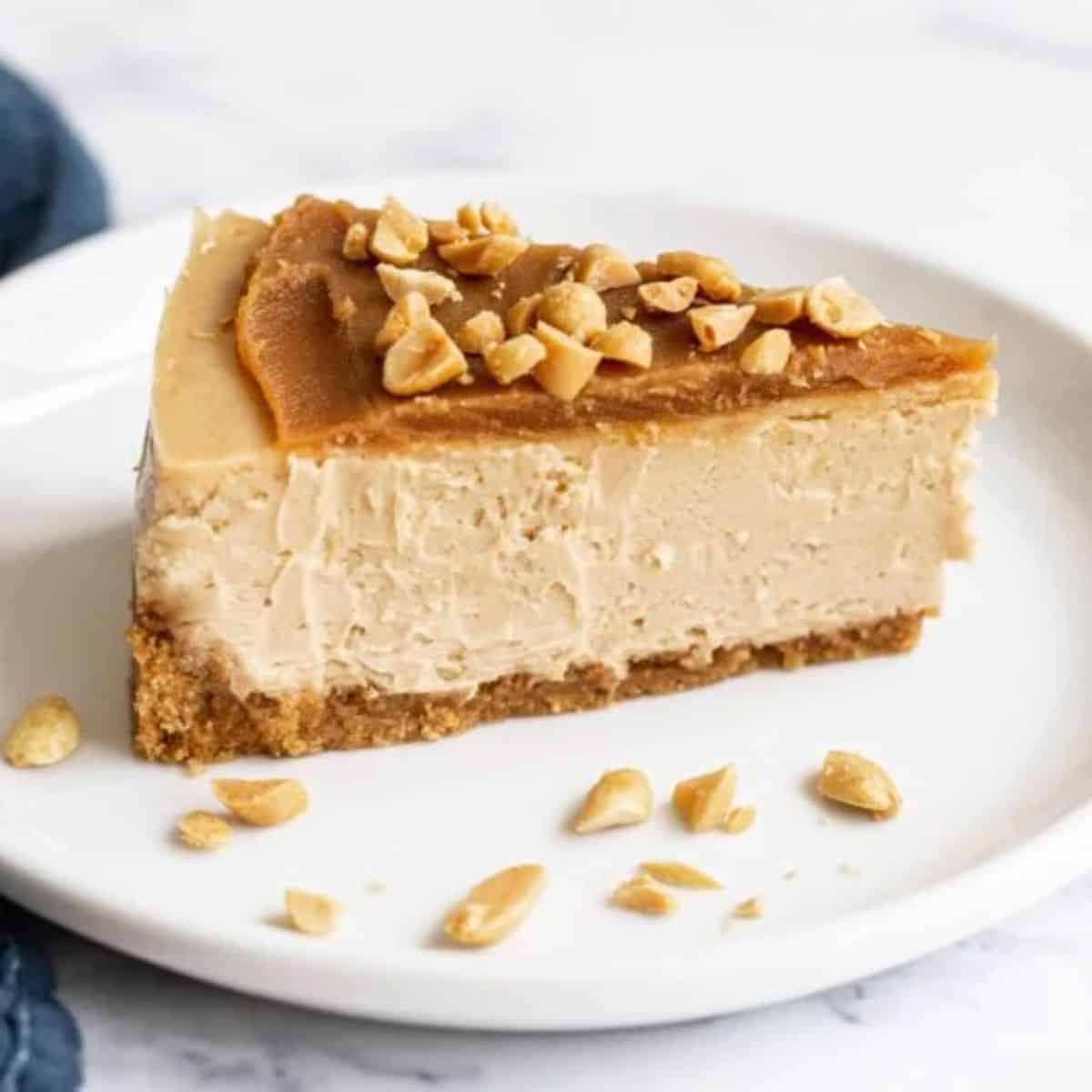 A piece of Ultimate Peanut Butter Cheesecake on a white tray.