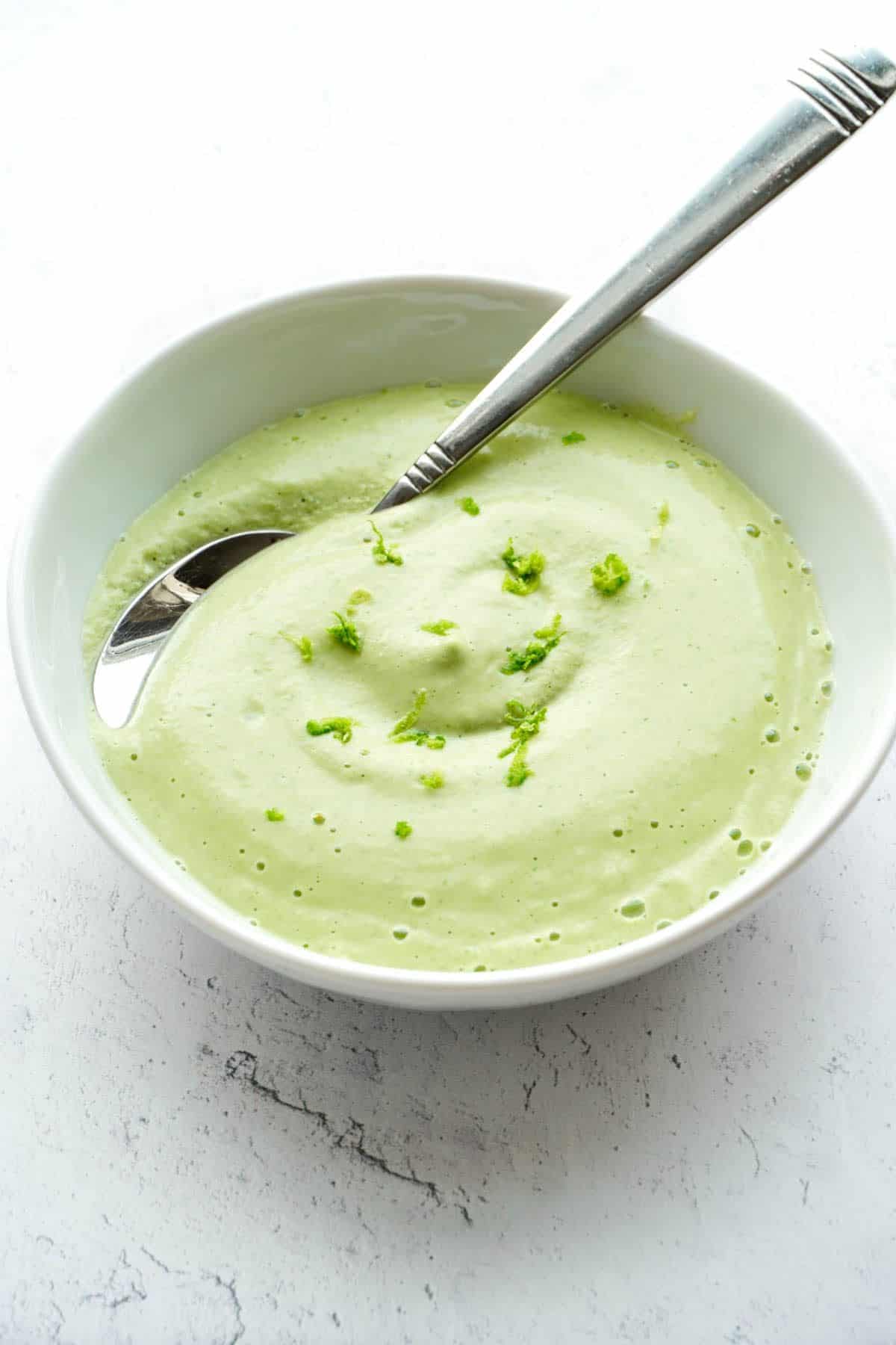 Cilantro Lime Cashew Cream in a white bowl with a spoon.