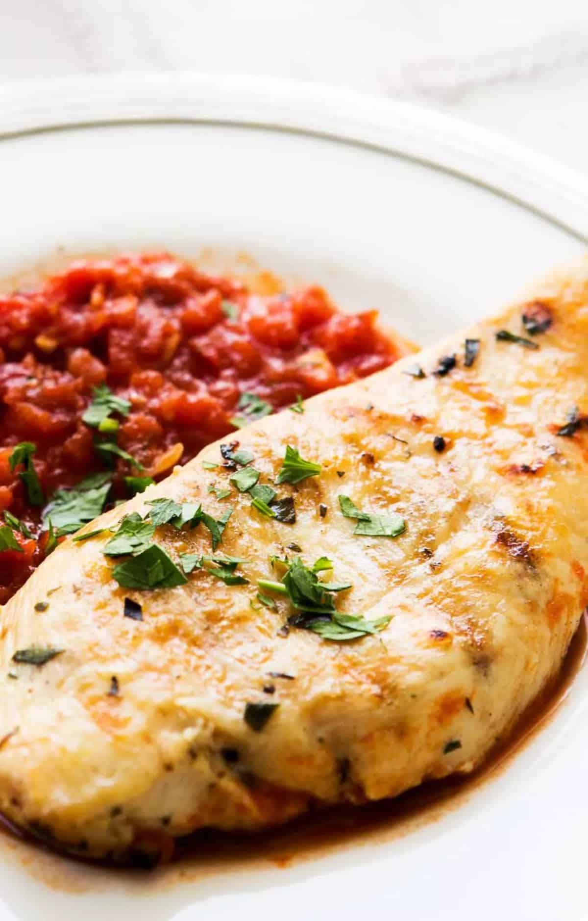 Delicious Grilled Chicken Tarragon With Tomato Sauce on a white plate.