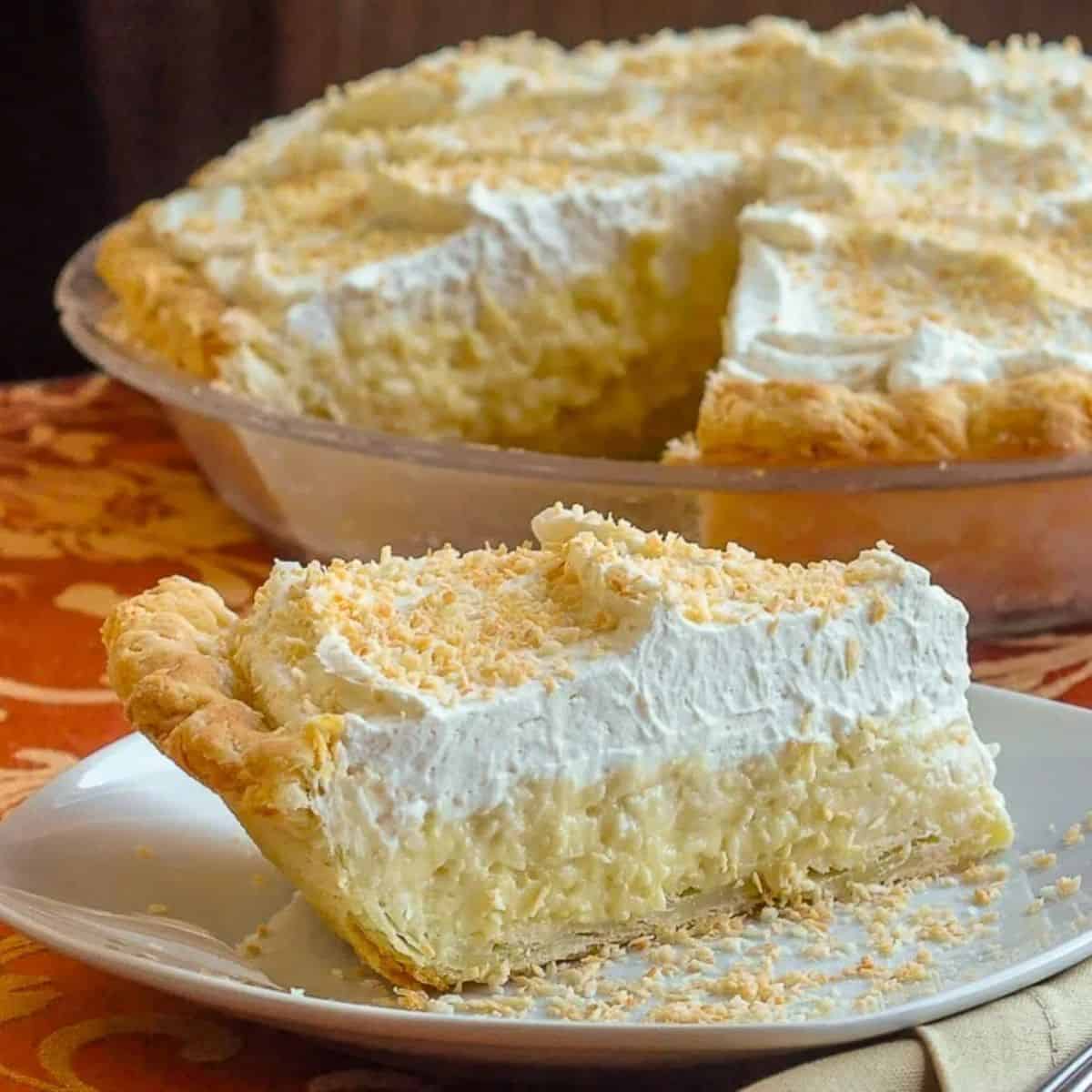 A piece of delicious Coconut Cream Pie on a white plate.