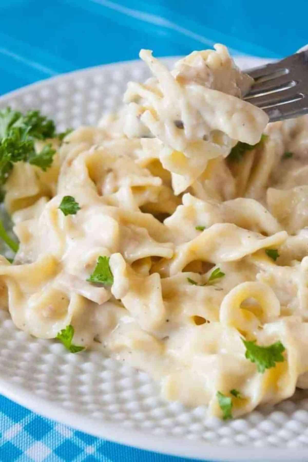 Instant Pot Tuna Noodle on a white plate picked with a fork.