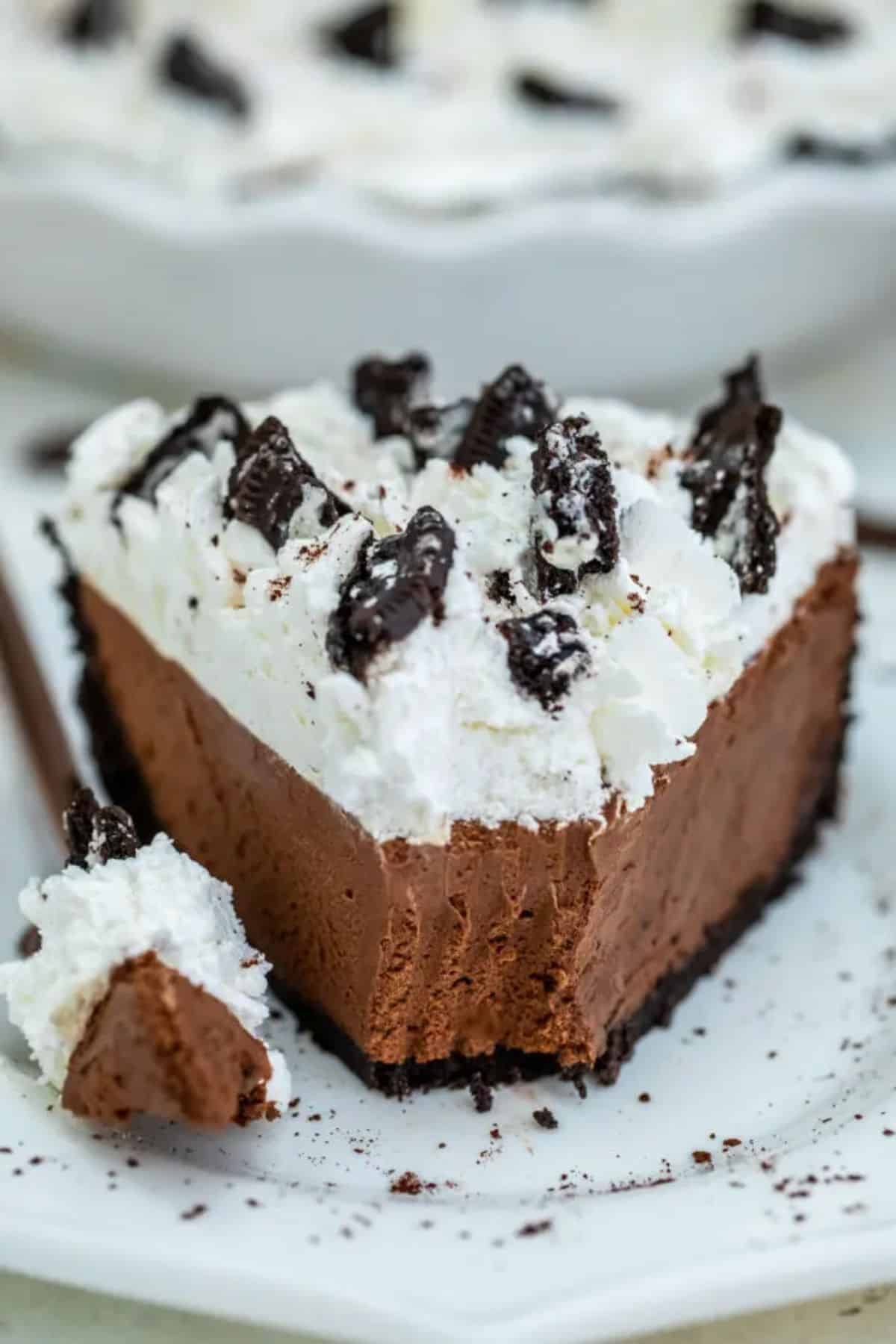 A piece of No-Bake Oreo Chocolate Pie on a white plate with a fork.
