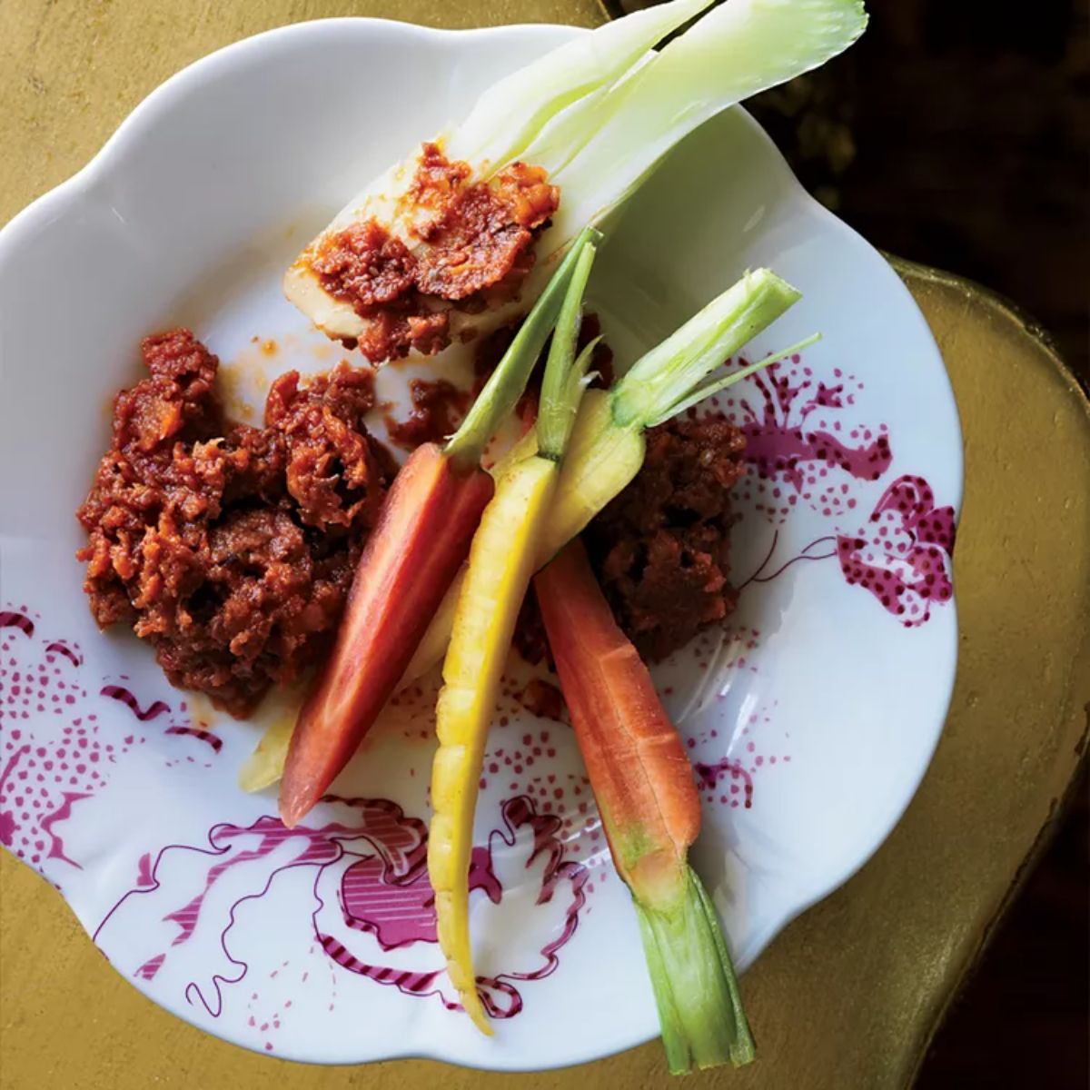 Tangy Sun-dried Tomato and Olive Dip with sliced veggies on a plate.