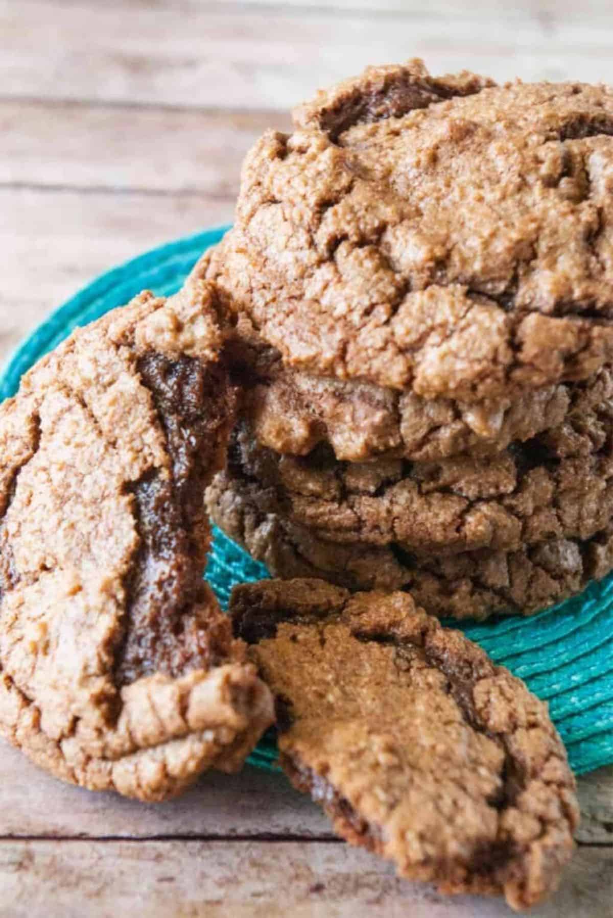 A pile of Chewy Chocolate Brownie Cookies on a wooden table.