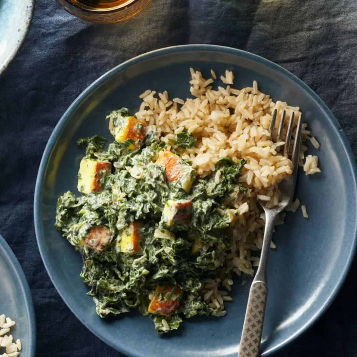 Turmeric Saag Paneer on a gray plate with a fork.