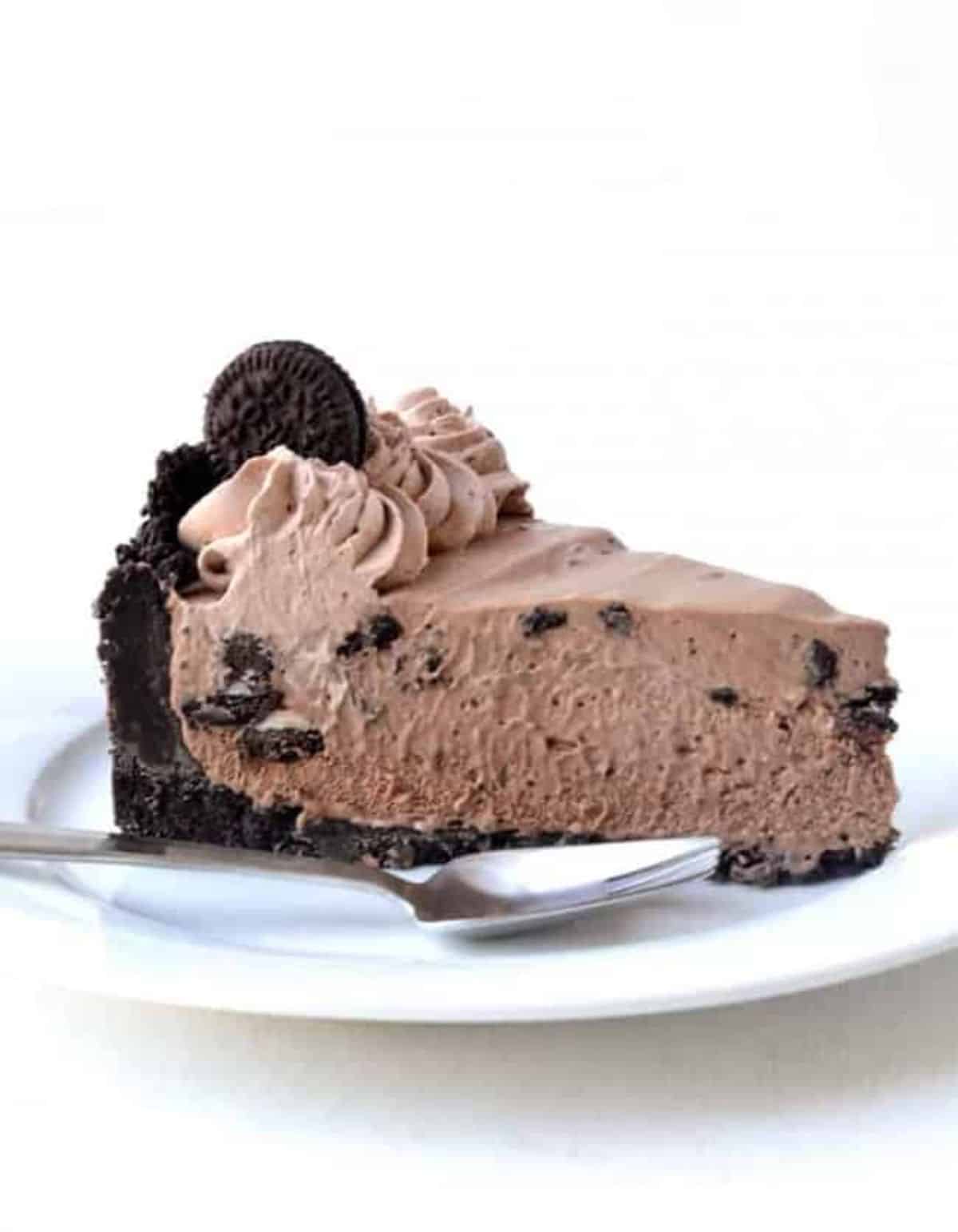 A piece of Oreo Ice Cream Pie on a white plate with a fork.