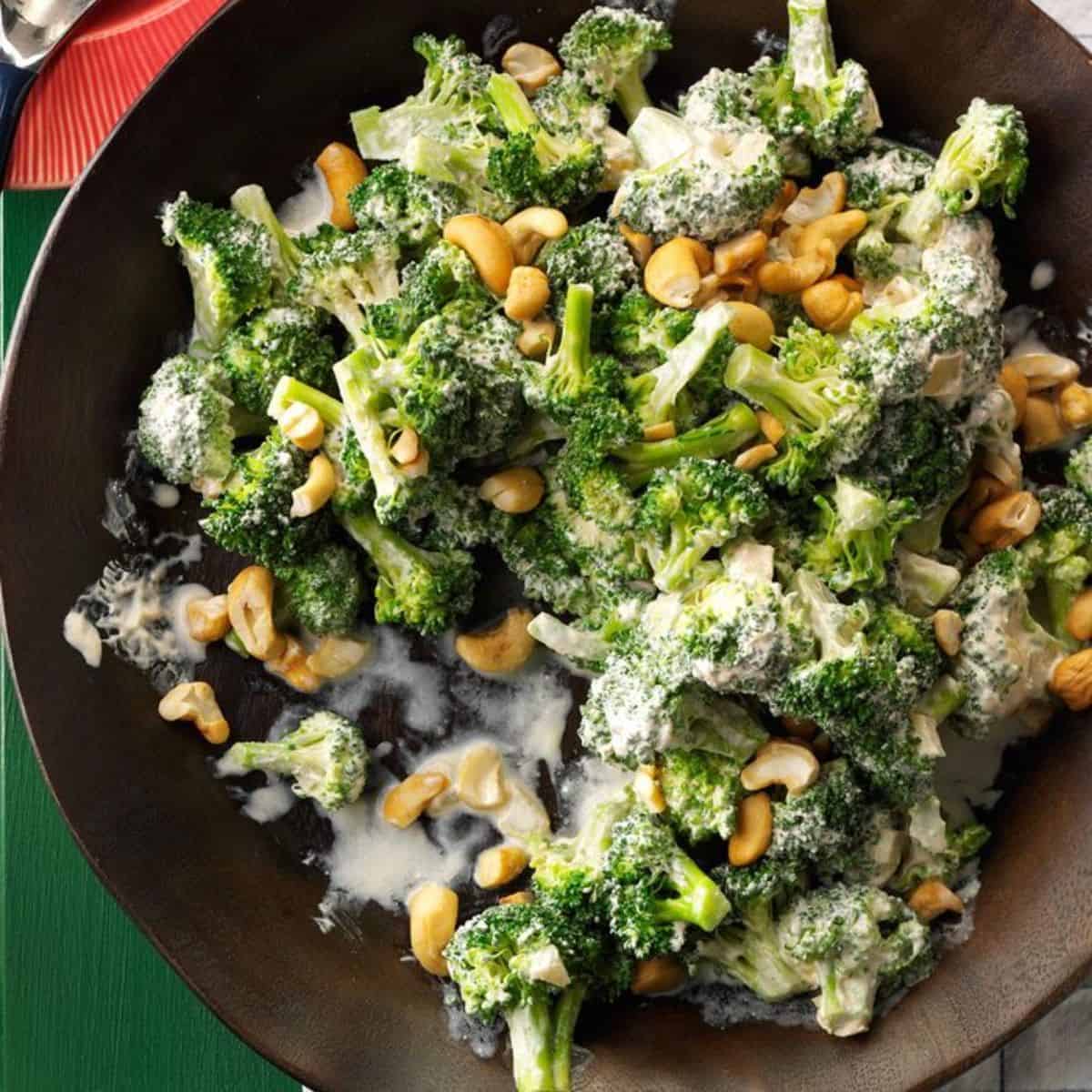 Creamy Broccoli with Cashews on a black plate.