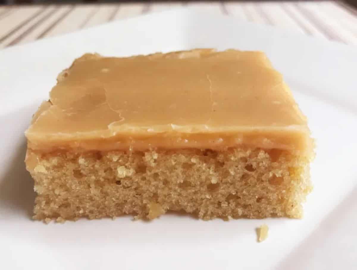 A piece of The Perfect Peanut Butter Sheet Cake on a white tray.