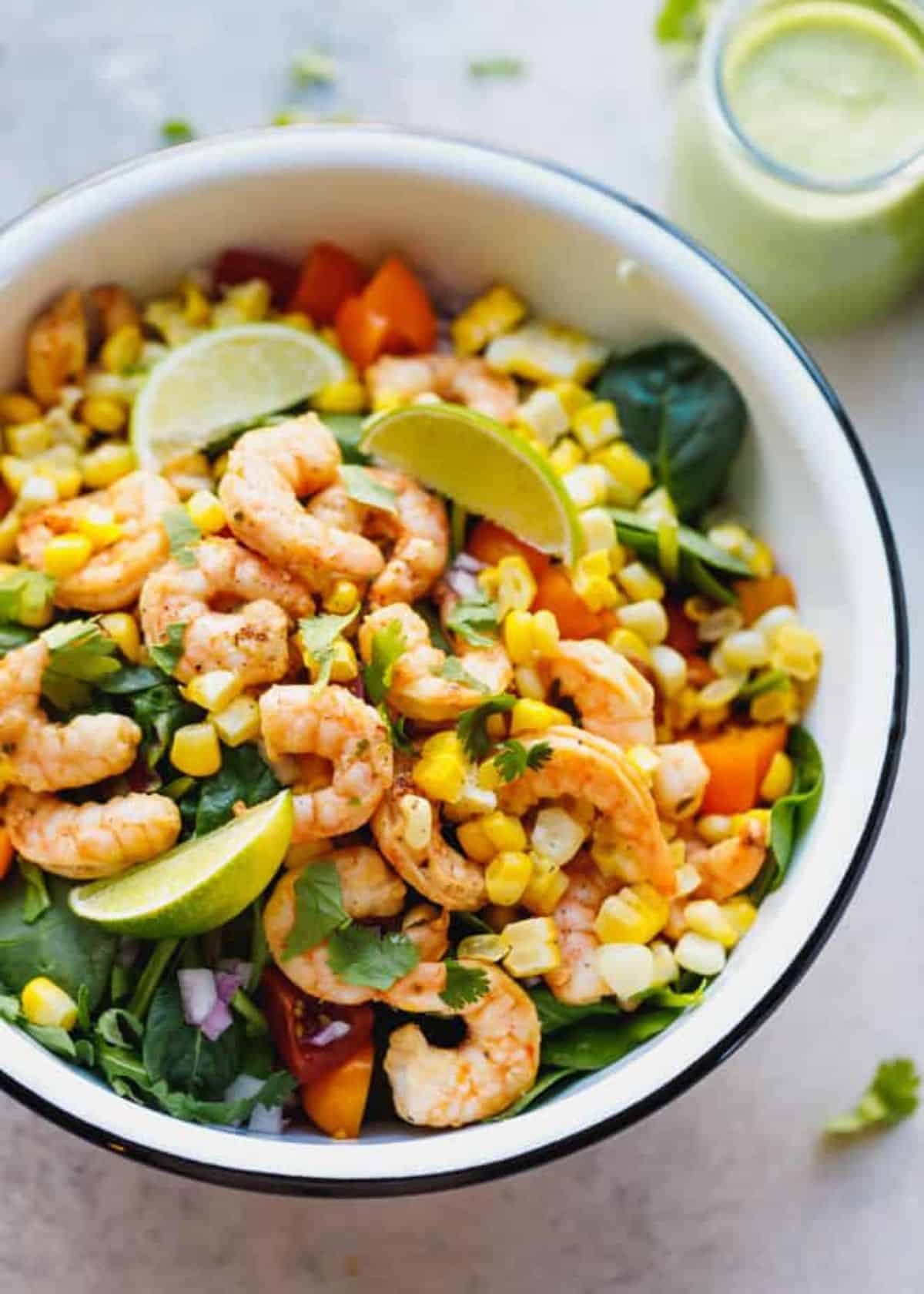 Tequila Lime Shrimp Salad with Cilantro Lime Dressing in a white bowl with a black edge.