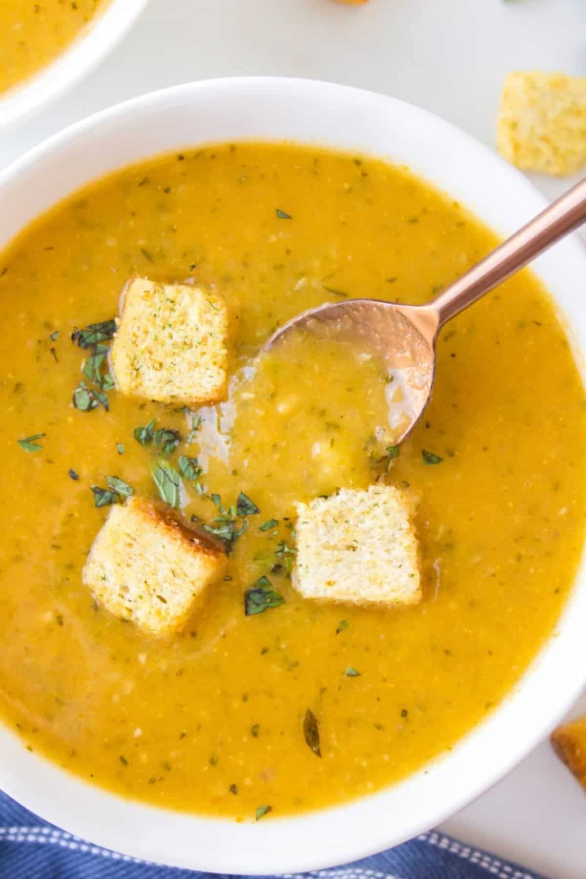 Zucchini Fresh Oregano Soup in a white bowl with a spoon.