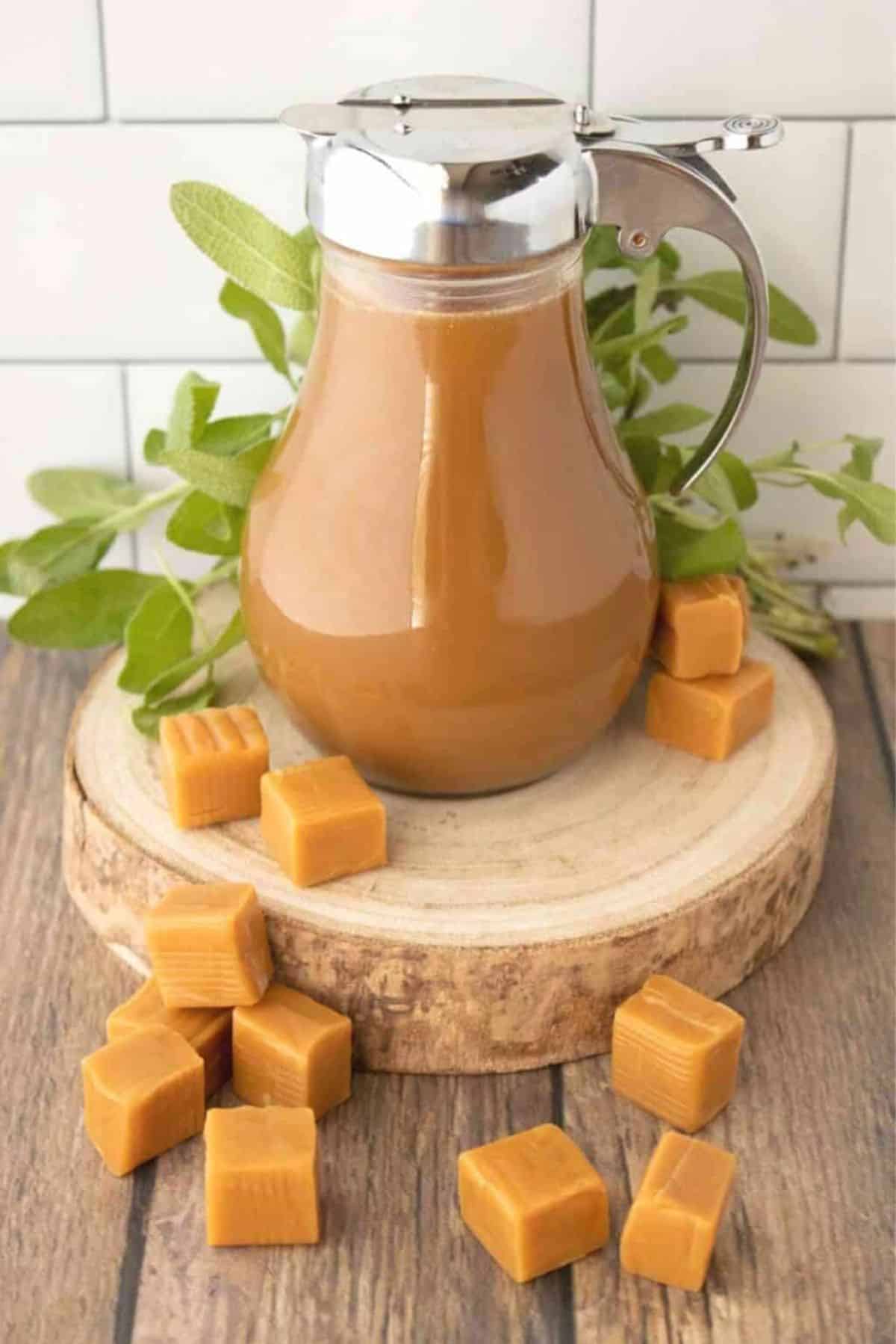 Caramel Syrup in a glass pitcher on a wooden board.