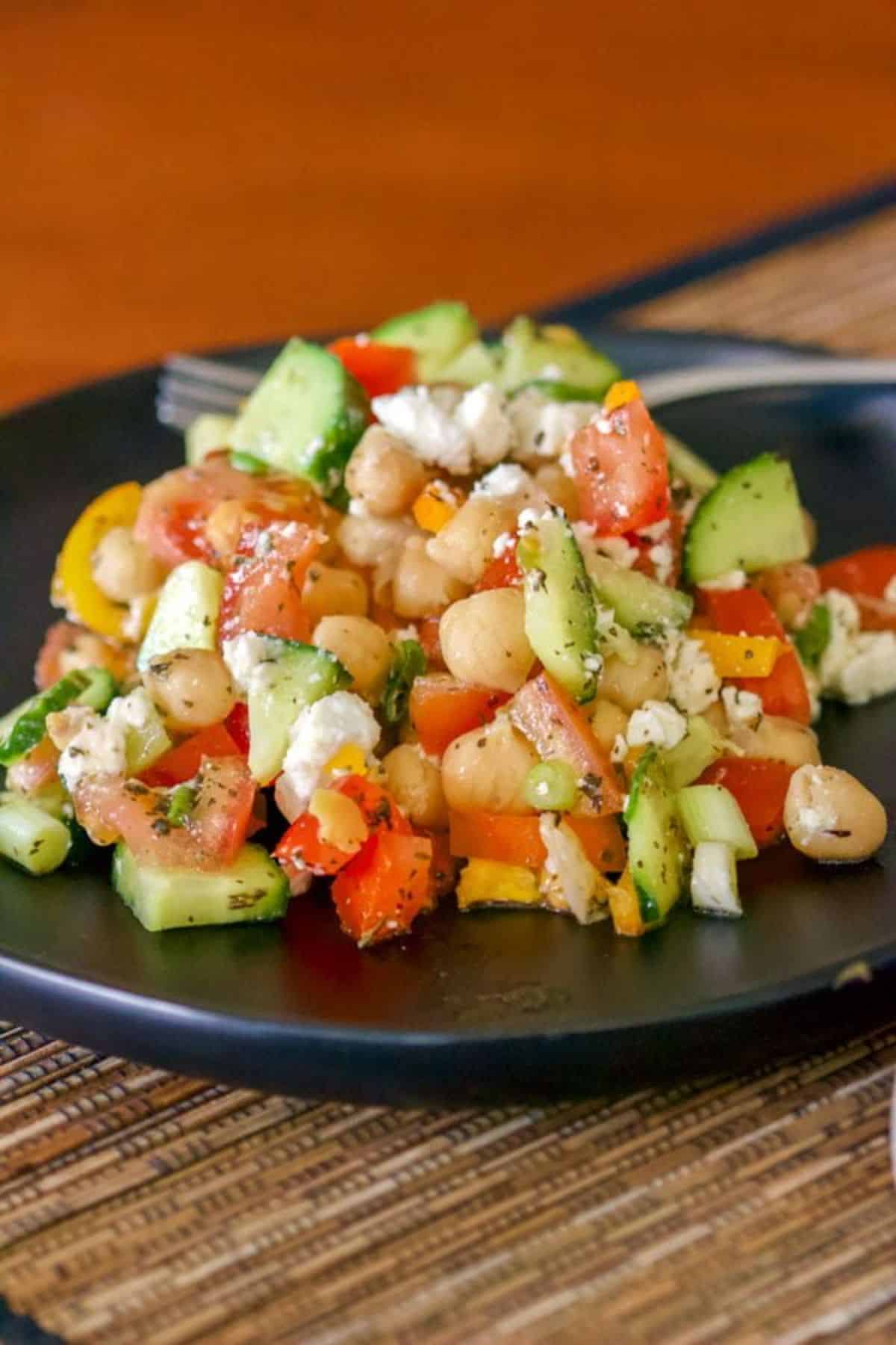 Easy Chickpeas Salad With Feta And Mint on a black plate.