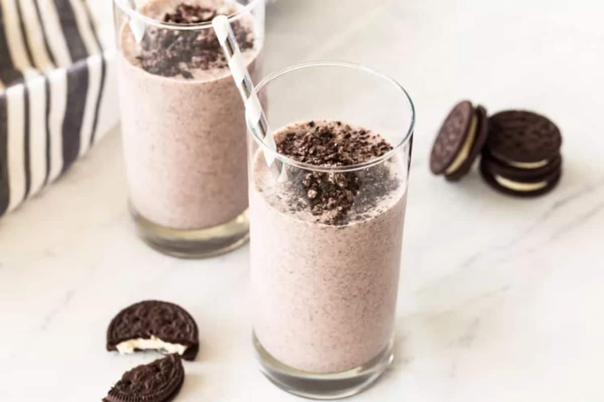 Oreo Milkshake in two glass cups with straws.