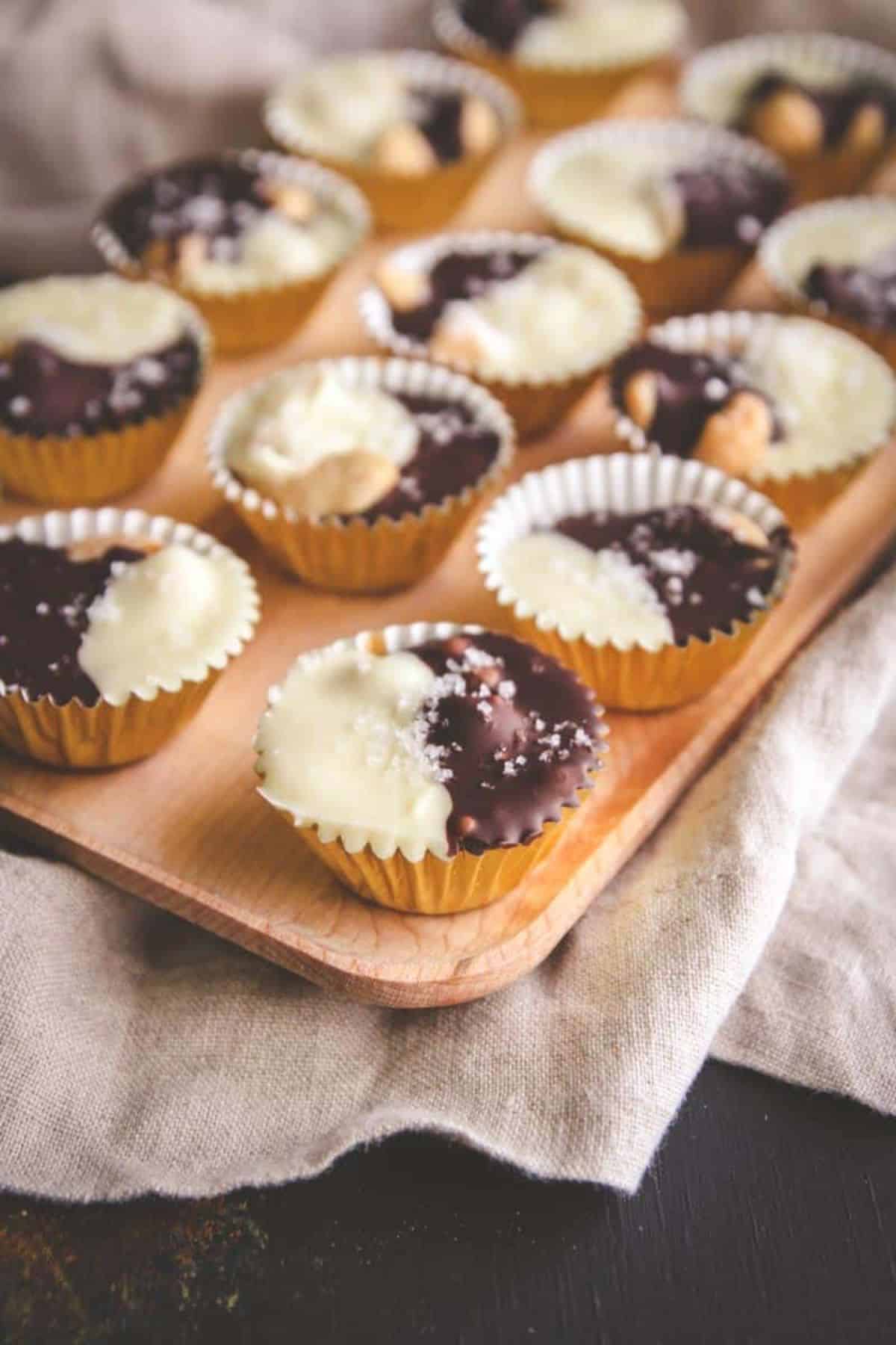 Salted Cashew Tuxedo Turtles on a wooden tray.