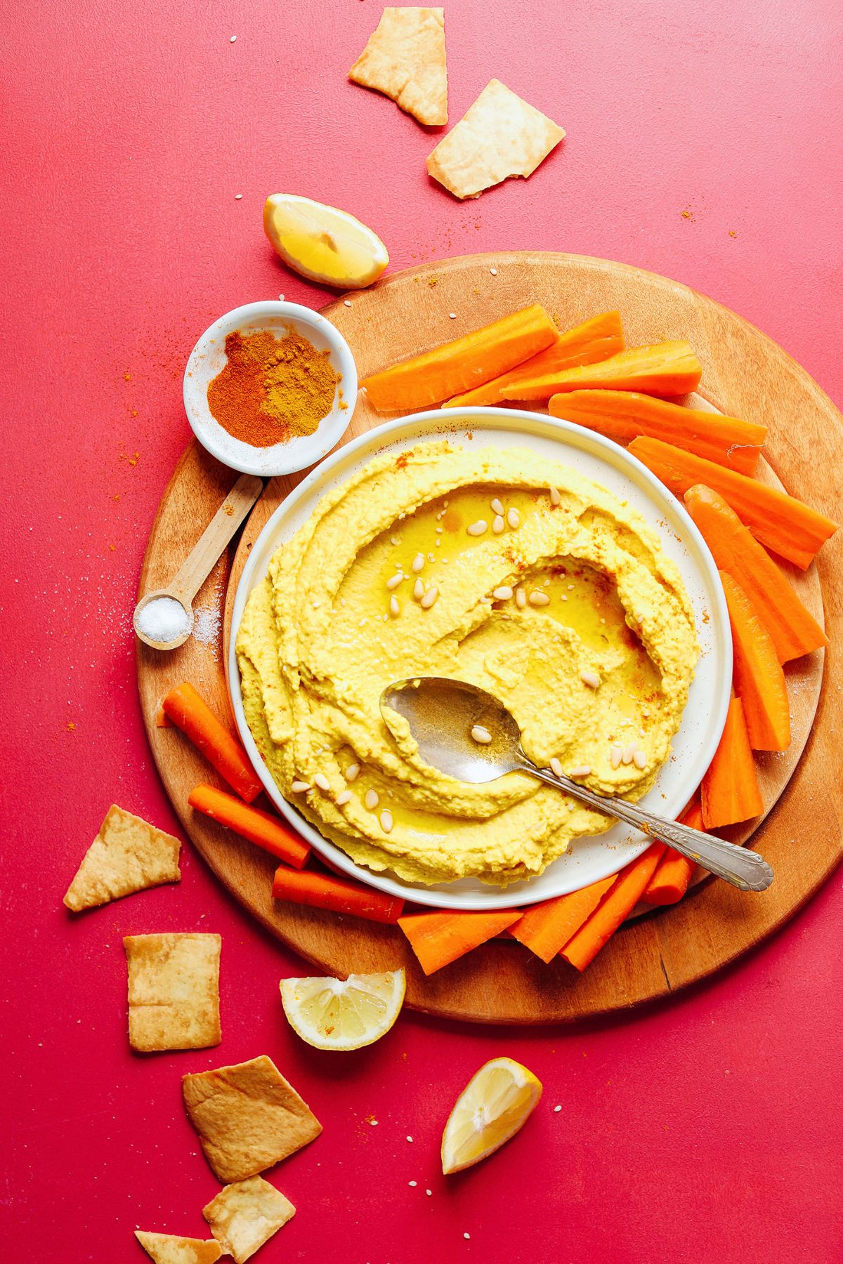 Golden Hummus in a white bowl with a spoon.