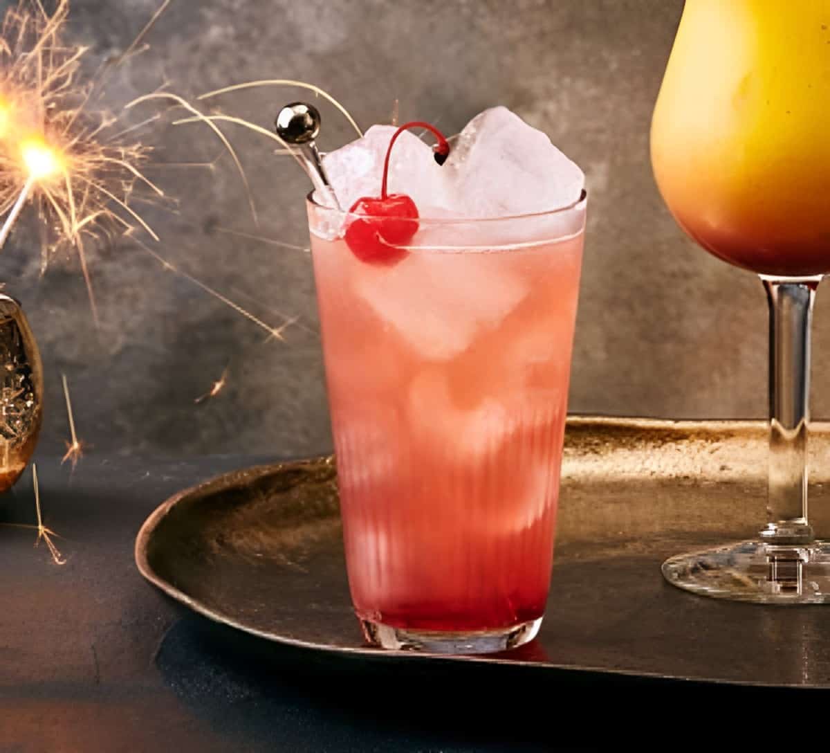 A fresh cocktail in a tall glass garnished with a cherry.