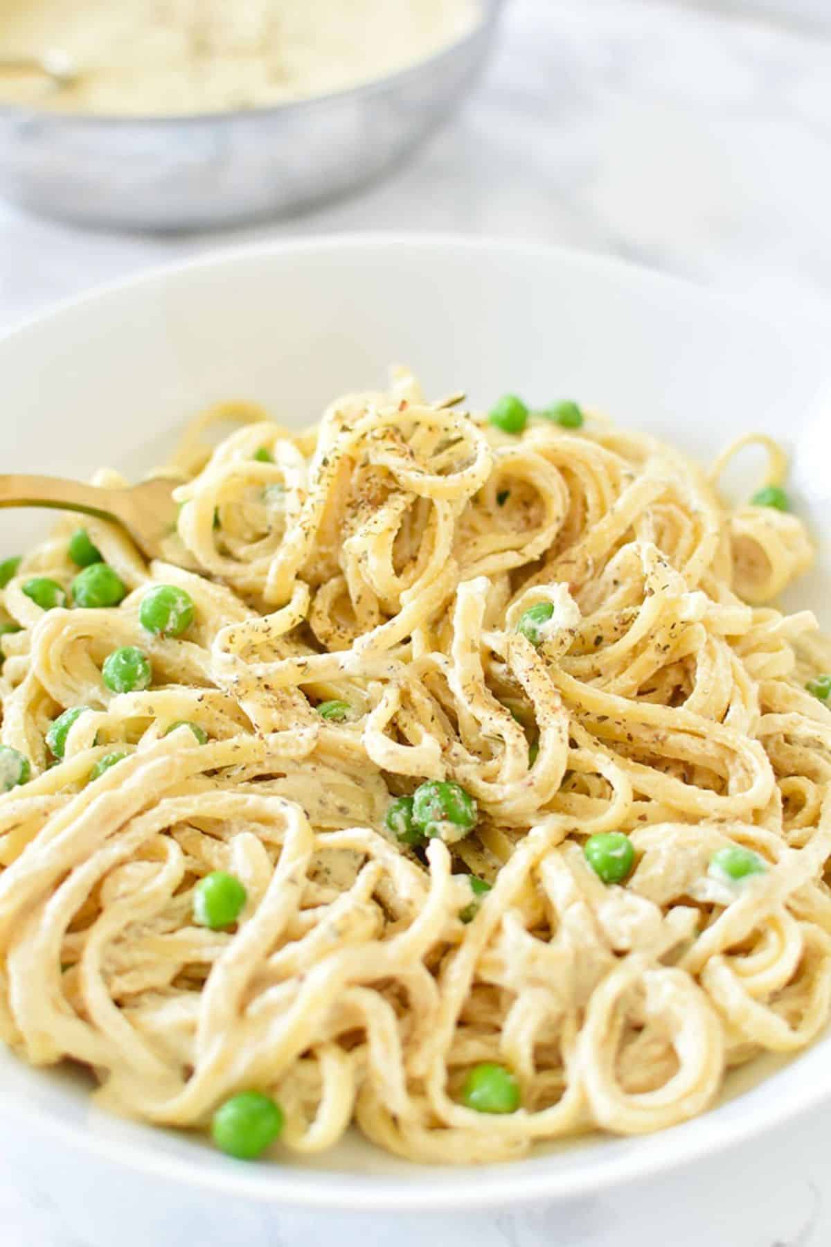 Easy Vegan Cashew Alfredo Sauce with noodles in a white bowl.