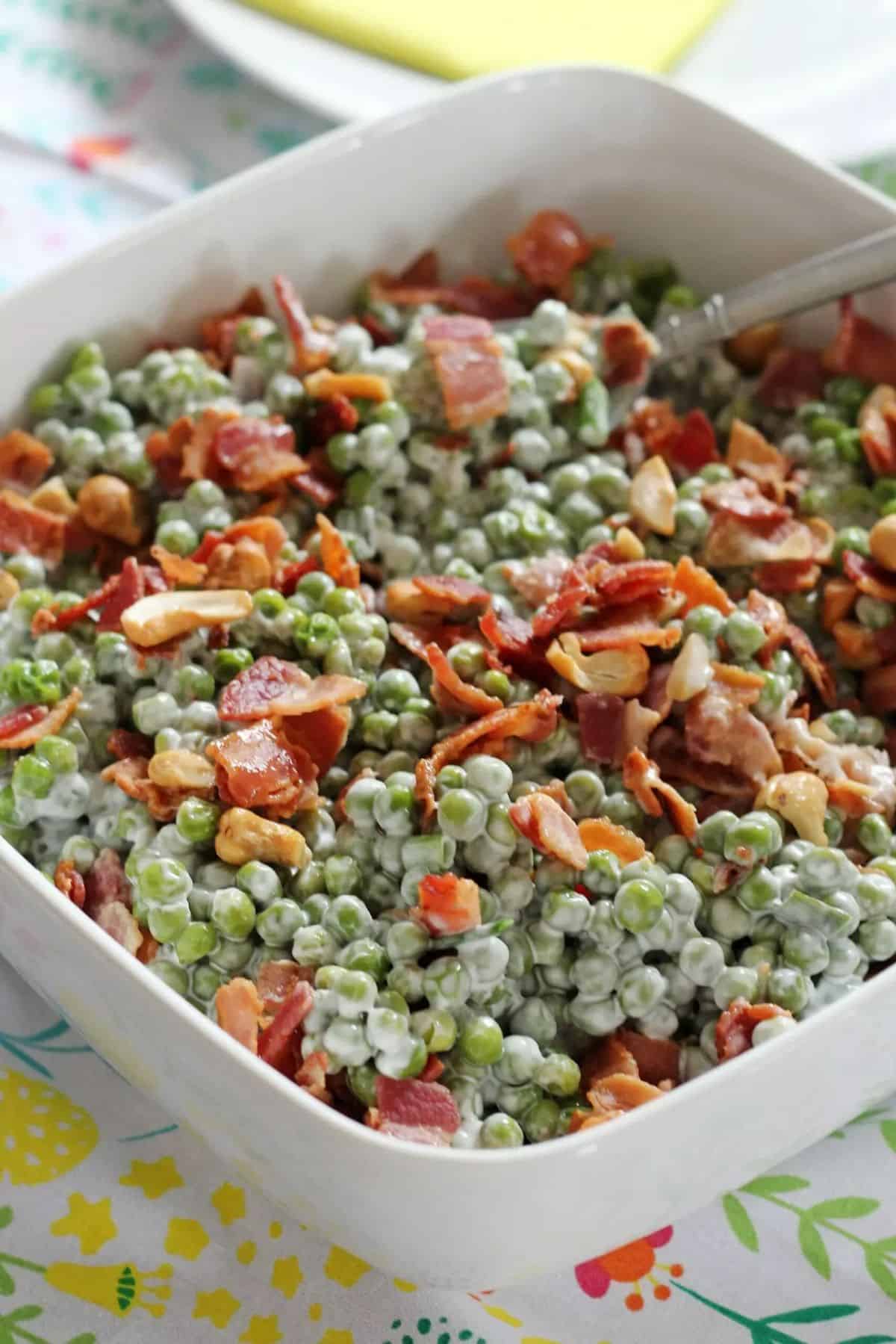 Crunchy Pea Salad with Bacon and Cashews in a white bowl.