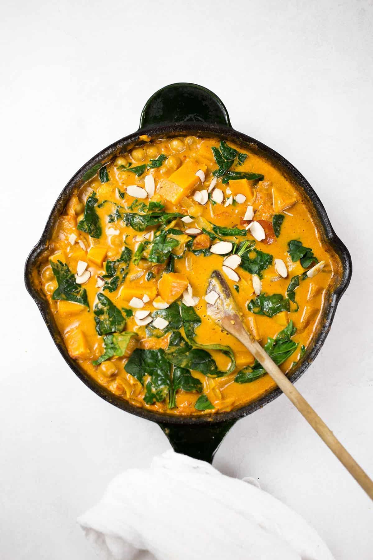 Delicious Butternut Squash and Chickpea Curry in a black skillet.