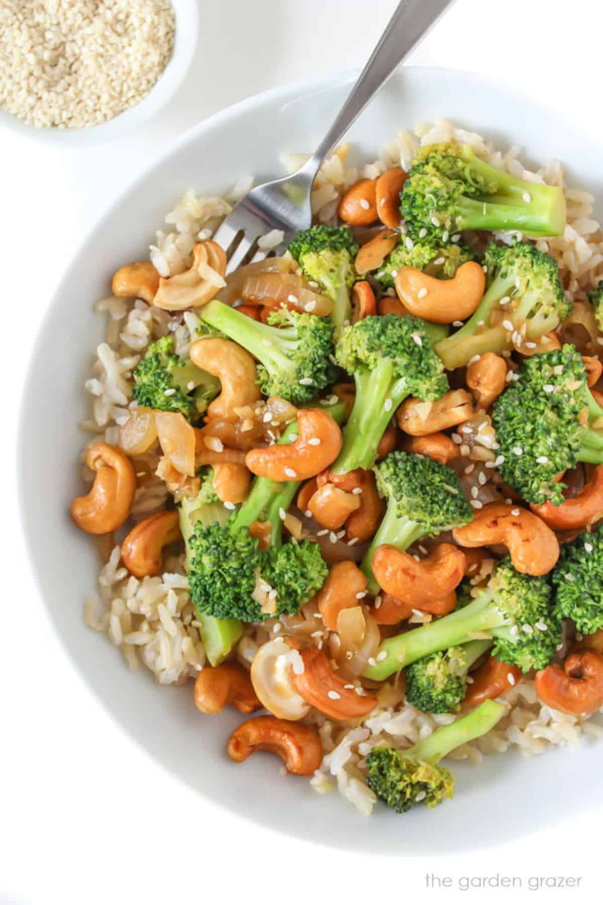 Broccoli Cashew Stir-Fry in a white bowl with a fork.