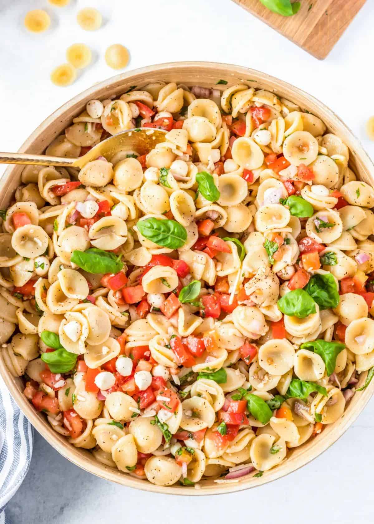 Caprese Pasta Salad in a bowl with a spoon.