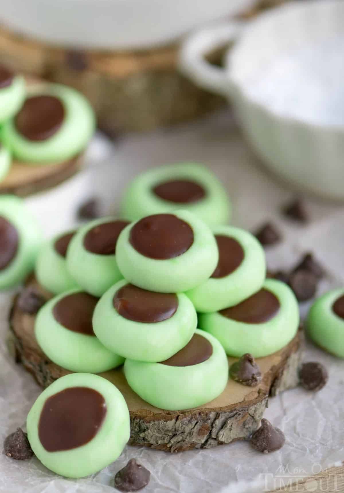 A pile of Chocolate Mint Cream Cheese Buttons on a wooden board.