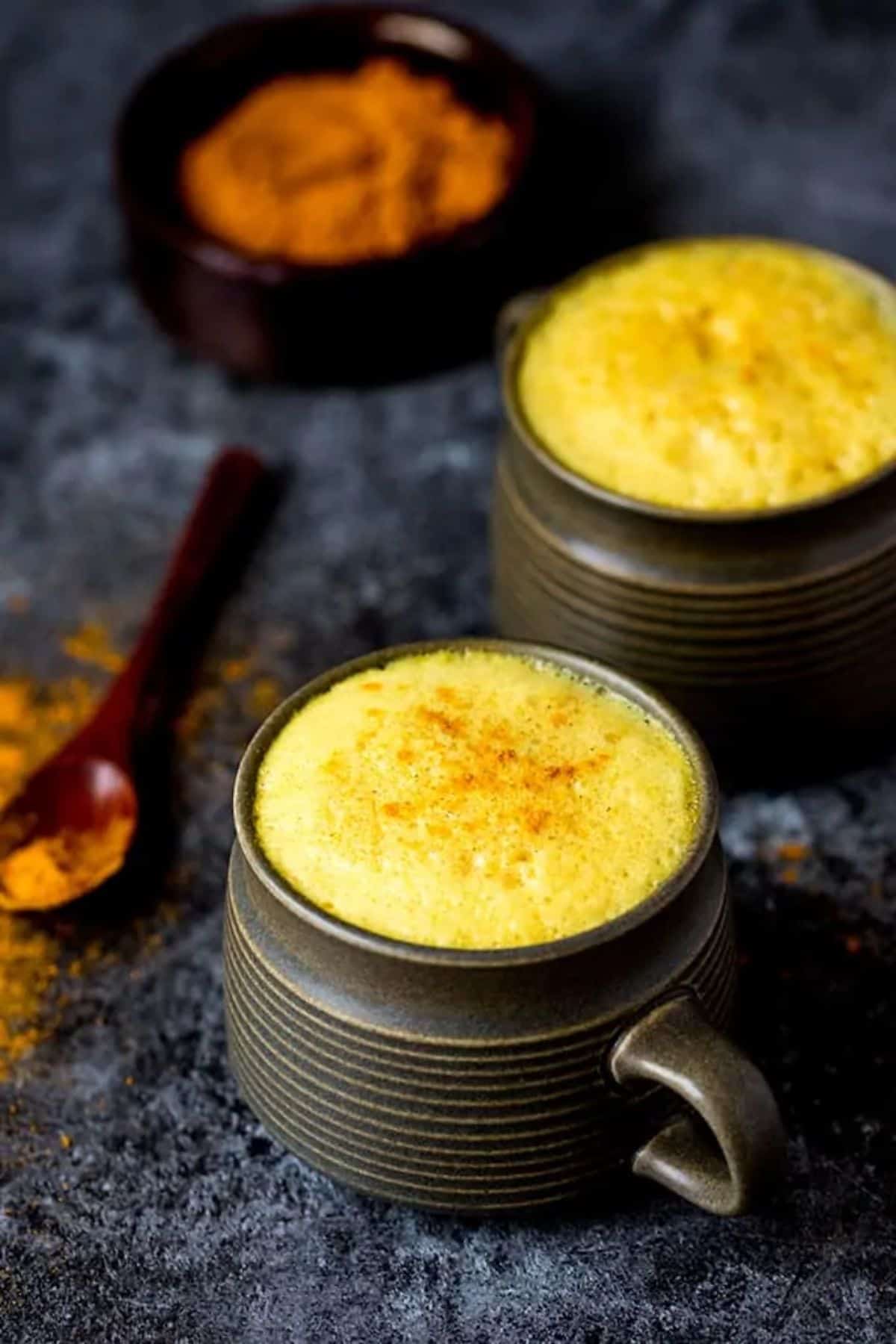 Turmeric Latte in two black cups.