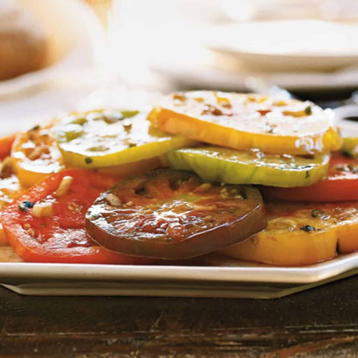 Marinated Heirloom Tomatoes With Tarragon on a white plate.