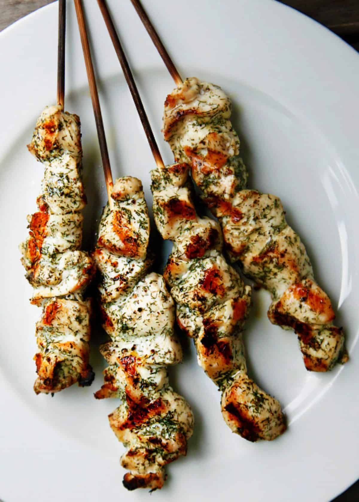 Dill and Lemon Chicken Skewers on a white plate.