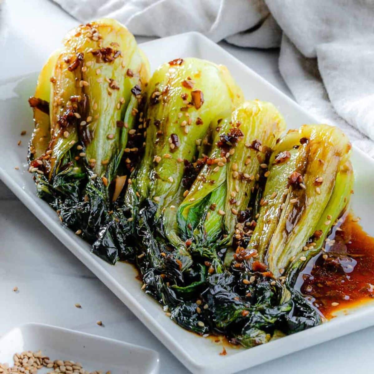 Scrumptious Baby Bok Choy With Soy Sauce and Garlic on a white tray.