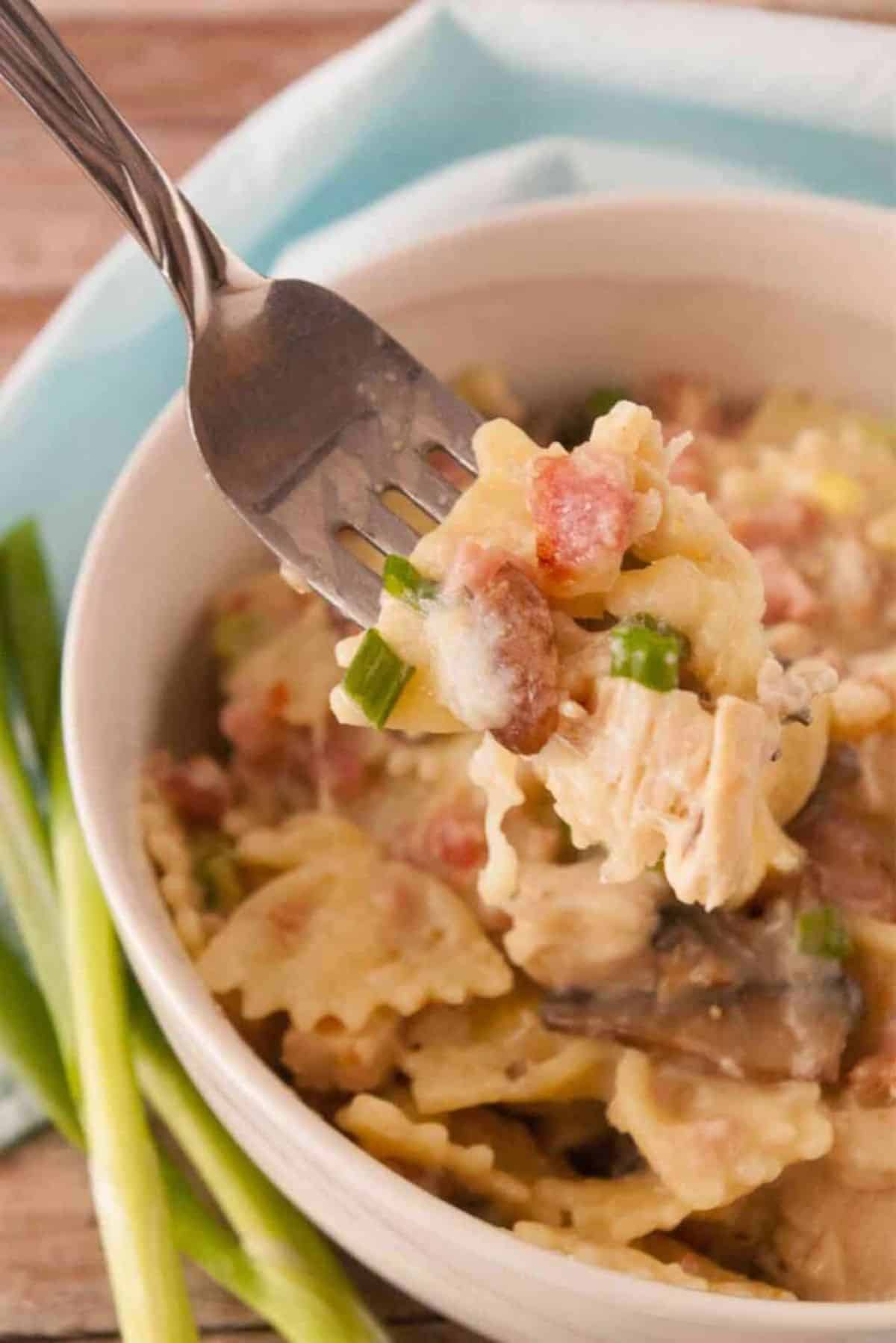 Chicken Cordon Bleu in a gray bowl picked with a fork.