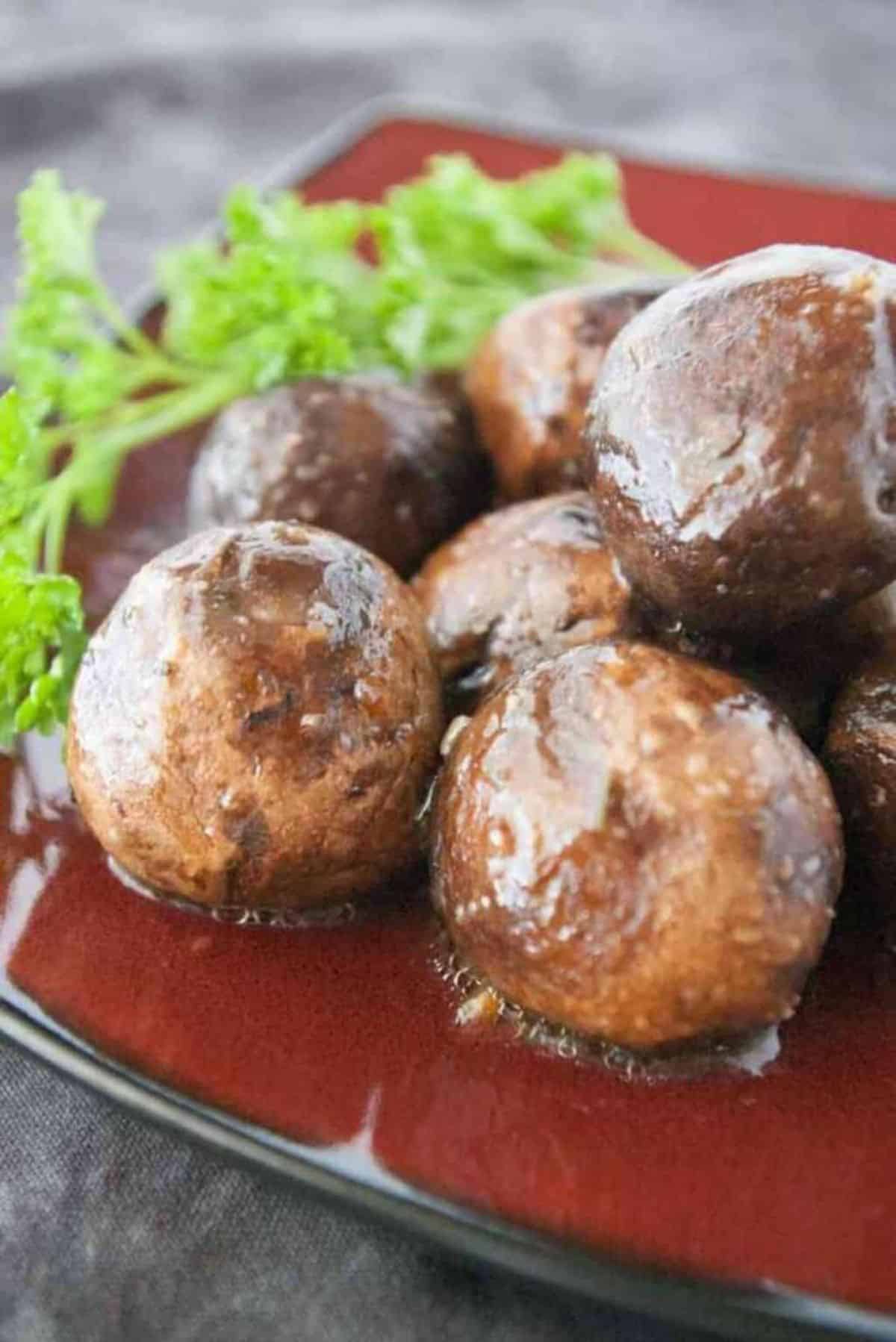 Delicious Slow Cooker Italian Mushrooms on a red plate.