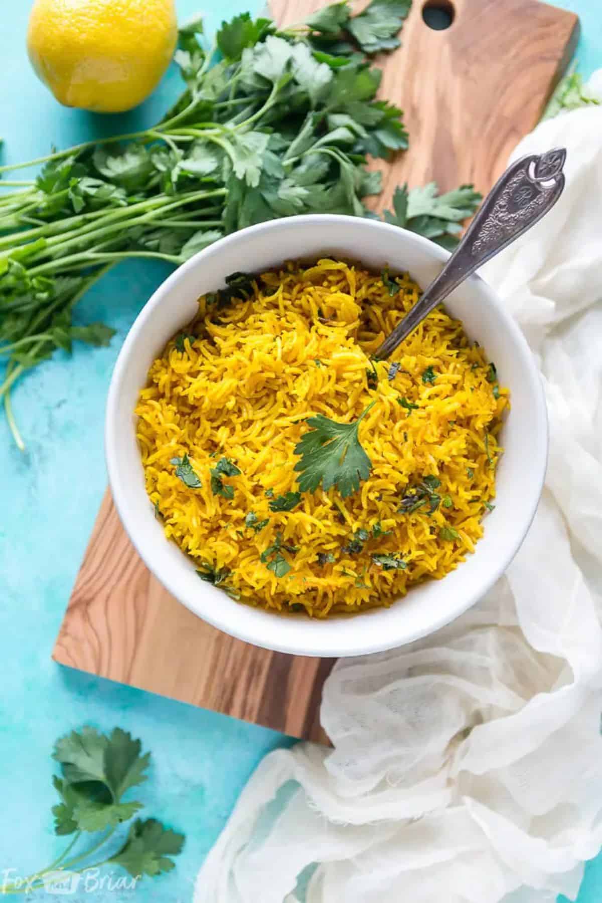 Turmeric Rice in a white bowl with a spoon.