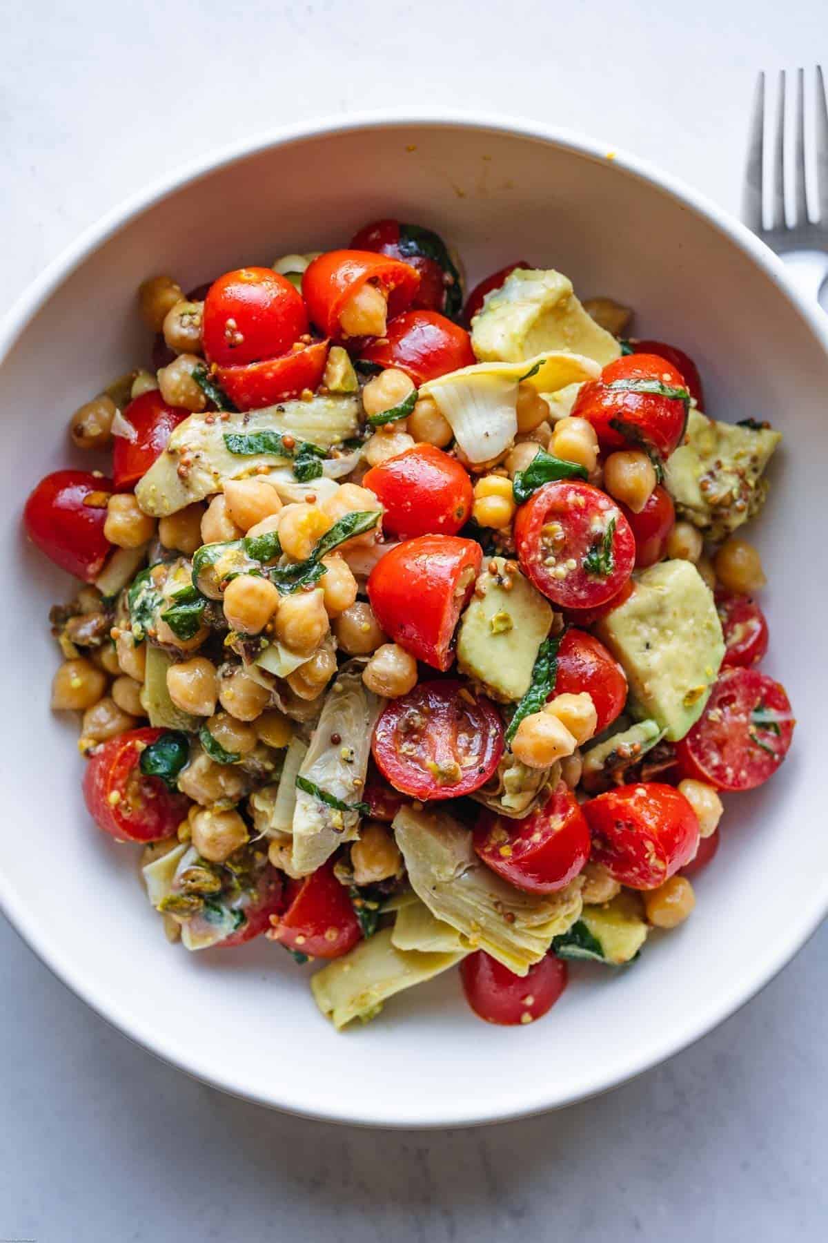 Scrumptious Tomato and Basil Salad with Chickpeas in a white bowl.