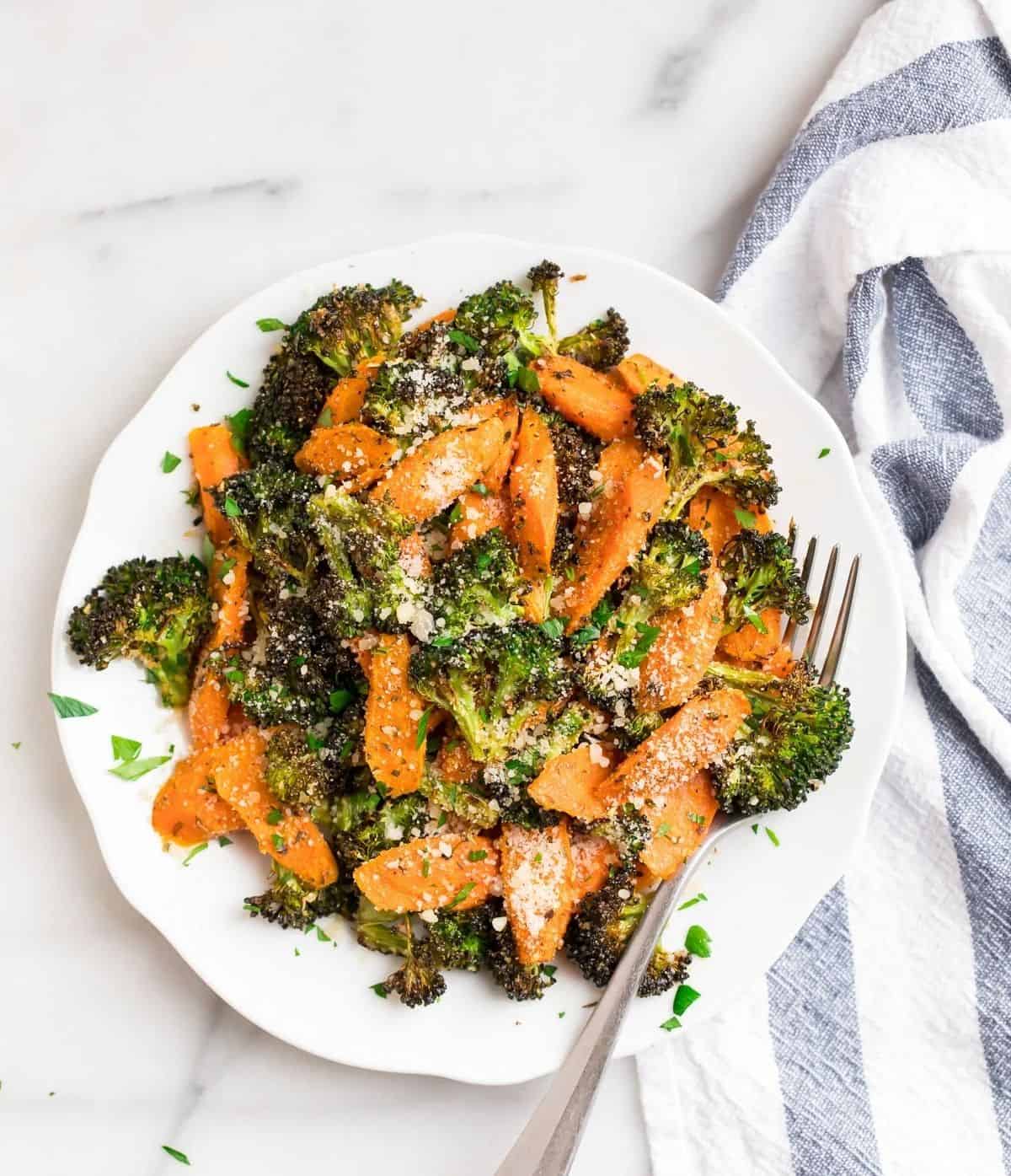 Healthy Roasted Broccoli and Carrots on a white plate with a fork.