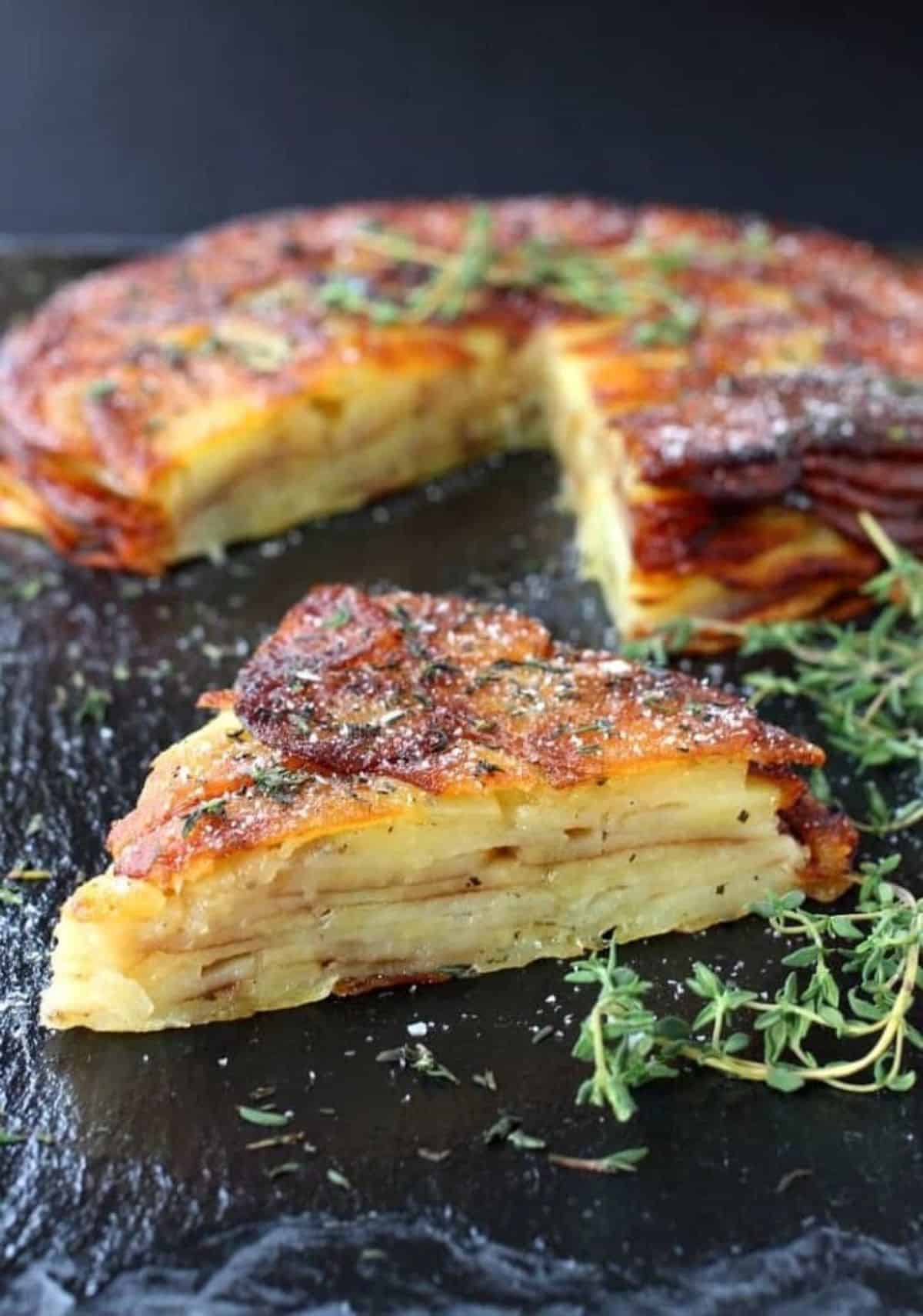 Scrumptious Brown Butter and Thyme Potato Torte on a black tray.