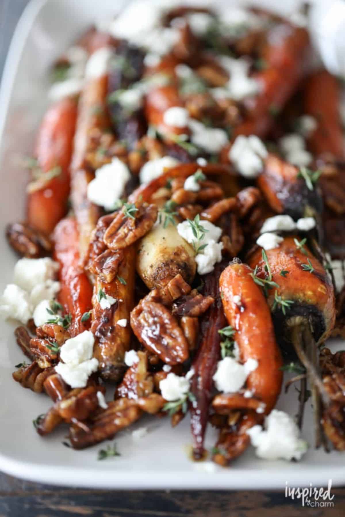 Healthy Roasted Carrots with Candied Pecans and Goat Cheese on a white tray.