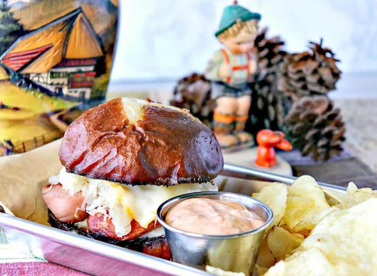 Delicious German Knockwurst Sausage Sandwich with chips and dip on a tray.