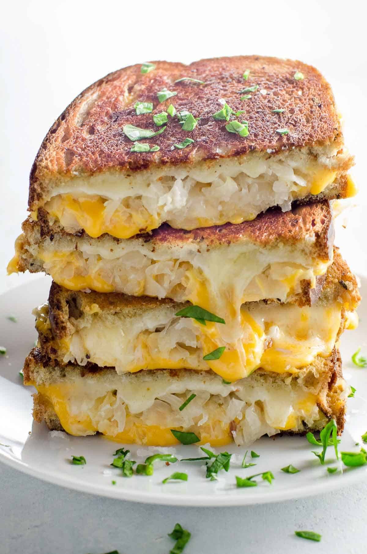 A pile of Sauerkraut Grilled Cheese With Dijon on a white plate.