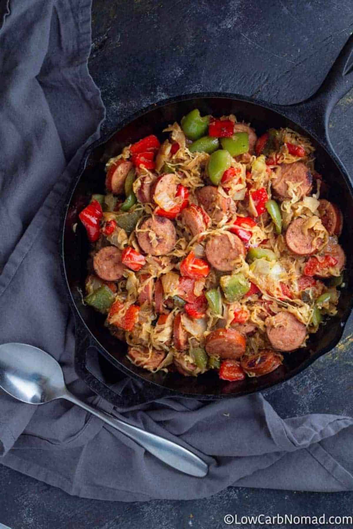 Delicious Kielbasa and Sauerkraut in a black skillet.