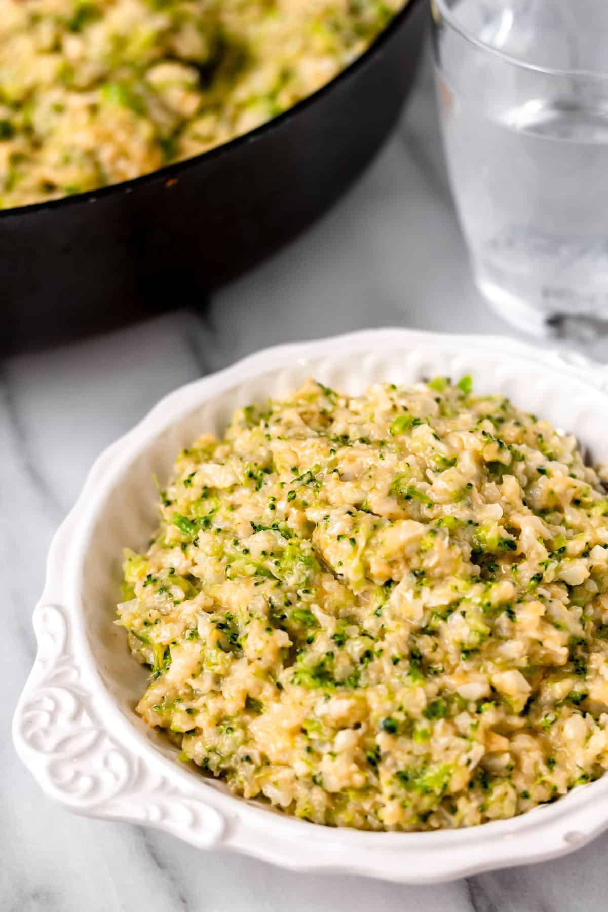 Flavorful Cheesy Broccoli Cauliflower Rice in a white bowl.