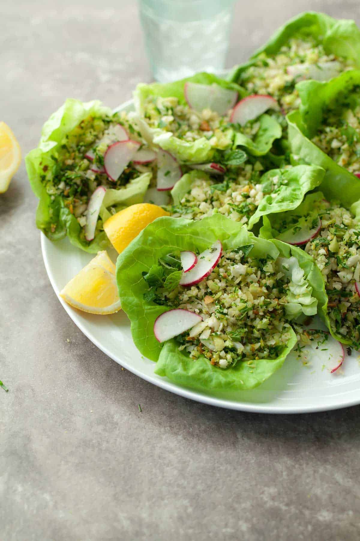 Scrumptious Broccoli, Cauliflower, and Couscous Lettuce Cups on a white plate.